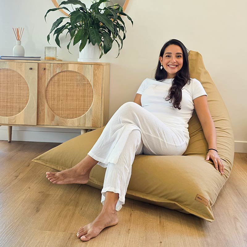 Tan structured Cotton Canvas Triangle seating by Mooi Living in a light-filled interior, adult woman seated.