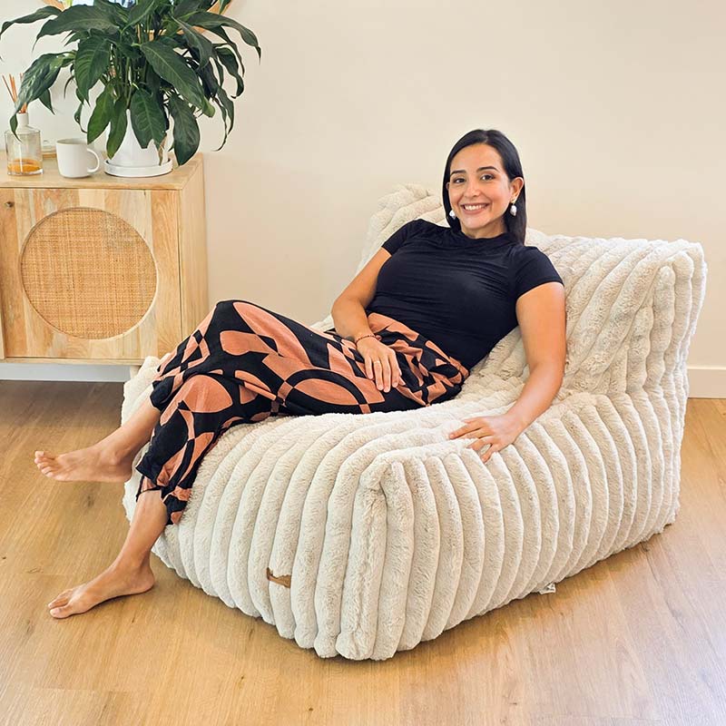 Brooklyn Luxe Lounger Foam Filled Bean Bag in Corduroy Faux Fur by Mooi Living in a living room, woman seated.