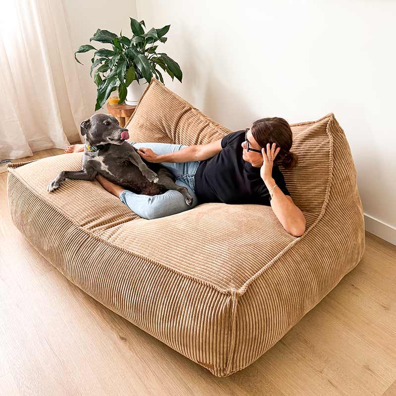 Caramel Mooi Double Seater Corduroy Bean Bag Lounger by Mooi Living styled indoors, woman lying down reading a book