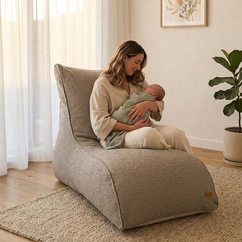 New mother holding her newborn baby while seater on a Taupe Boucle Indoor Bean Bag Lounger