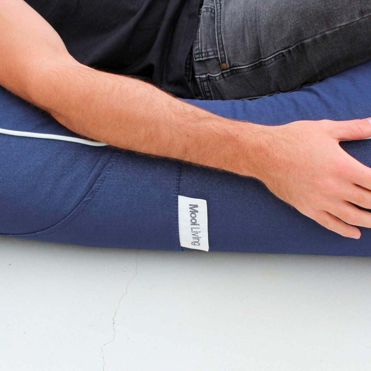 Close-up of the navy fabric, white piping, stitched seam and Mooi Living label on an Isla outdoor bean bag sunlounger, MOISLABB-NVY