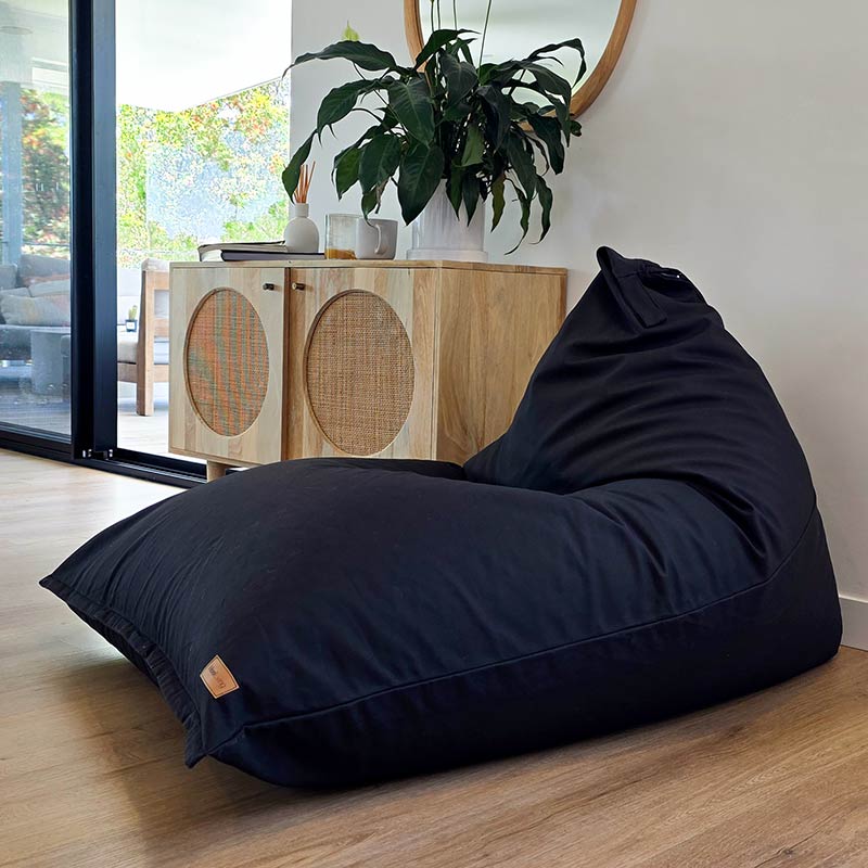 Black Large Cotton Canvas Triangle Bean Bag Chair by Mooi Living positioned in a minimalist living space with clean architectural lines.
