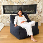Contemporary living room featuring the Black Bouclé Serena modern bean bag chair, indoor bean bag by Mooi Living, with an adult seated.