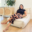 In a contemporary Australian living room, a woman sits on the Mooi Living Single Boss Bean Bag in Natural 100% cotton canvas.