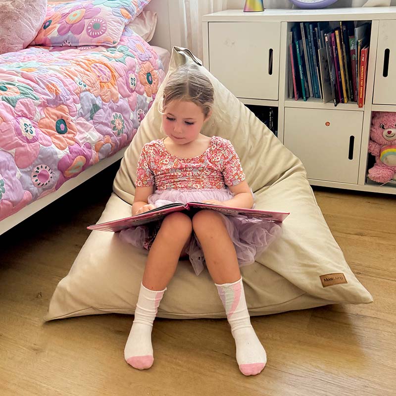 100% Cotton Canvas Mini Triangles in Natural by Mooi Living with young girl sitting and reading a book.