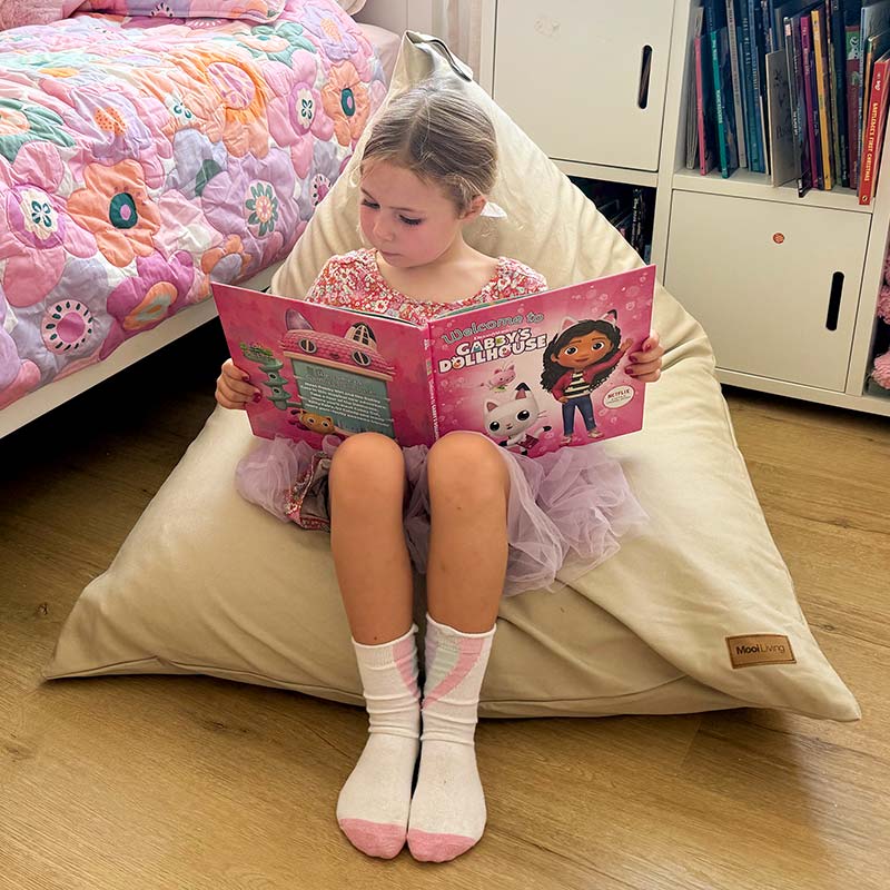 100% Cotton Canvas Mini Triangles in Natural indoor bean bag by Mooi Living with a young girl sitting and reading a book.