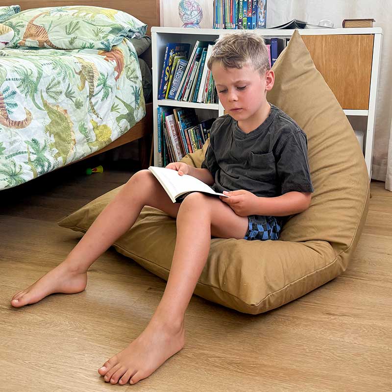 Tan 100% Cotton Canvas Mini Triangles by Mooi Living styled indoors, young boy seated and reading.