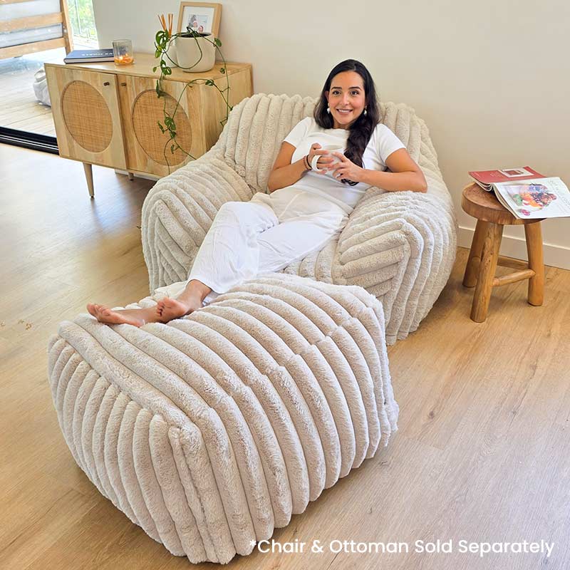 Callie Corduroy Faux Fur Armchair Foam Filled Bean BAg by Mooi Living with matching ottoman, woman seated in living room. Ottoman Sold Separately.