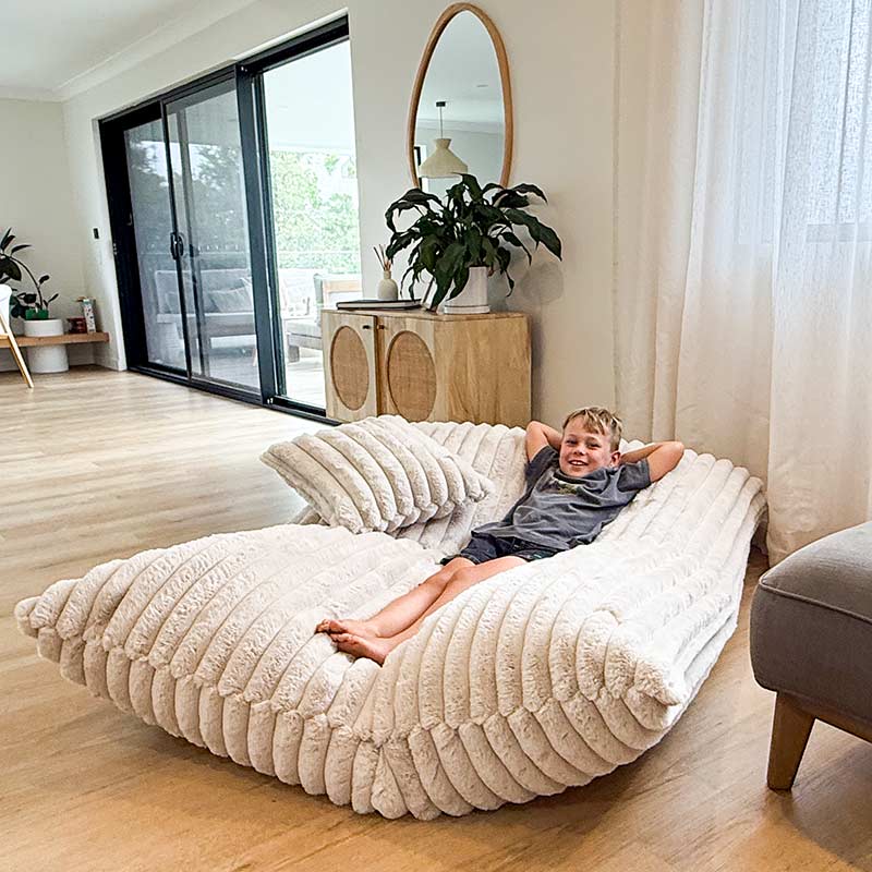 Large champagne plush bean bag mat with young boy lounging comfortably