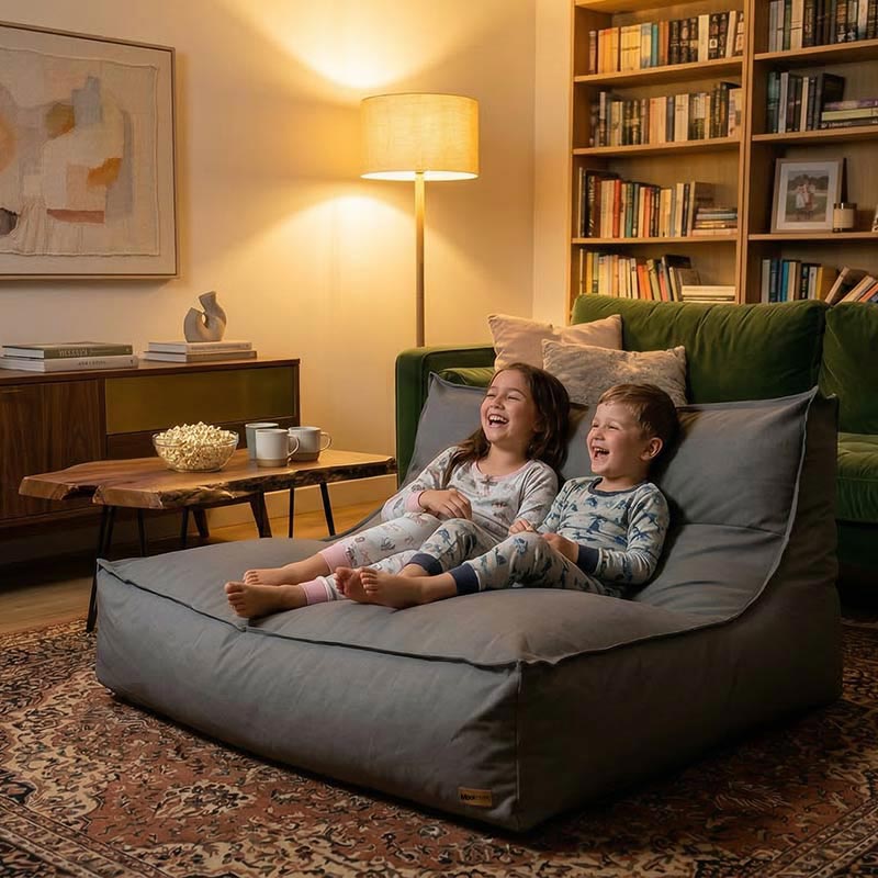 Two young children are lounging on a Cotton Double Boss Bean Bag Lounger indoor bean bag by Mooi Living, laughing at a movie.