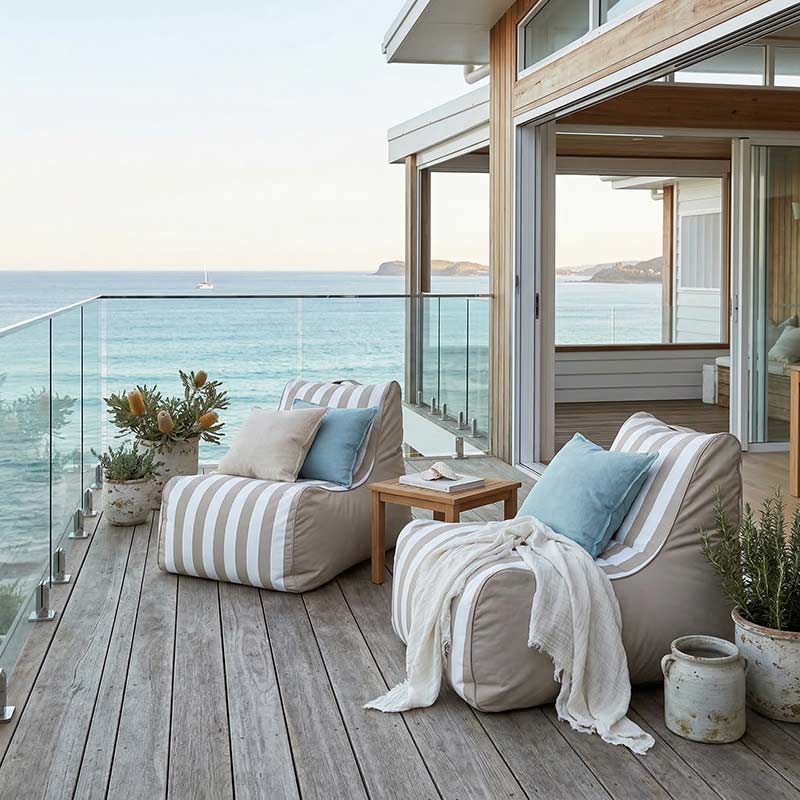 Lifestyle Image - 2 Bora Bora Bean Bag Chairs styled with pillows and throw on balcony overlooking the ocean.