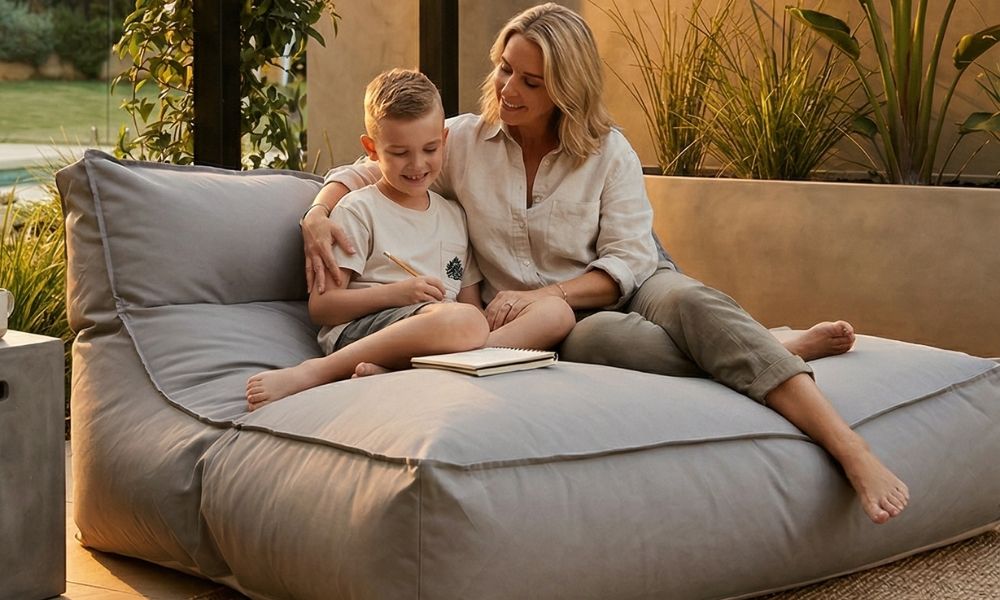 Woman and a child sitting on a Lana Lounger Outdoor Bean Bag by Mooi Living, reading together.