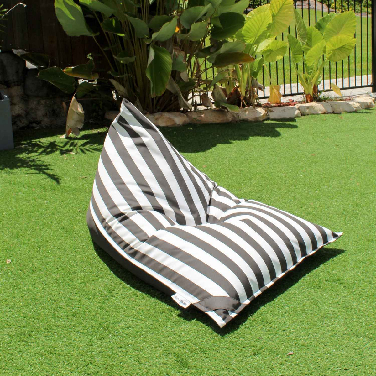 Mooi Living Oyster Black reversible triangle outdoor bean bag on grass, showing its oyster and black striped side, MOREVSTRIBB-BLASTR