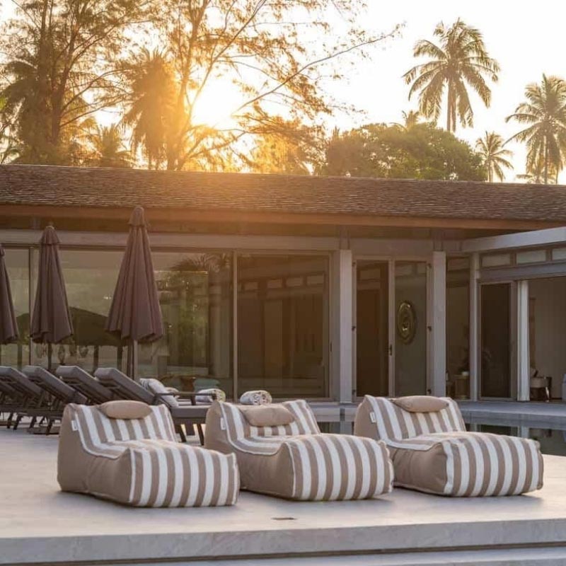 Three Taupe Stripe Cojelo Suave Sunloungers by Mooi Living placed side by side poolside at Villa Essenz Natai, customer photo by @Villa_essenza_natai.