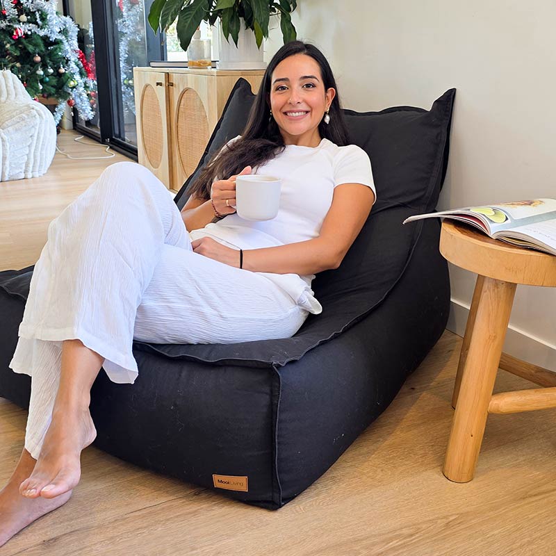 Mooi Living Black Single Boss oversized bean bag positioned in a minimalist home with model.
