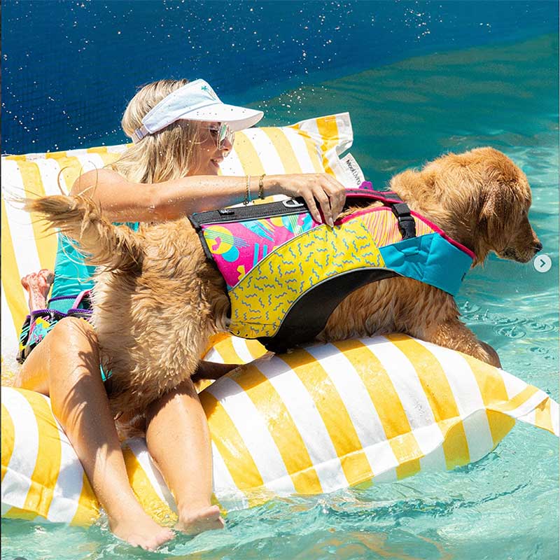 Customer pic of the Santorini Pool Float in Yellow Stripe with a woman and a dog enjoying floating in the pool.