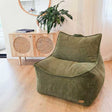 Olive green corduroy indoor bean bag chair by Mooi Living in a room with a wooden cabinet and plant.
