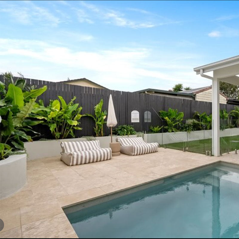 Taupe Stripe Double Seater Chill UV Loungers by Mooi Living poolside with umbrella and greenery, customer photo by @house.of.arco.