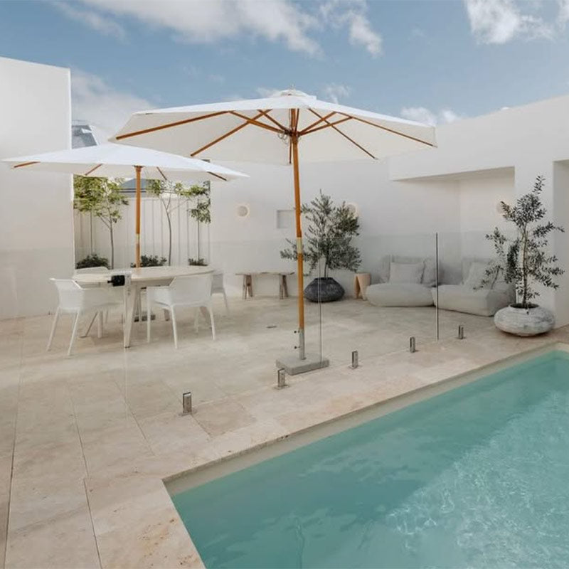 Natural Chill UV Double Seater Bean Bags by Mooi Living poolside with white outdoor furniture, umbrella, and olive trees, styled by @hudsonyard_design.