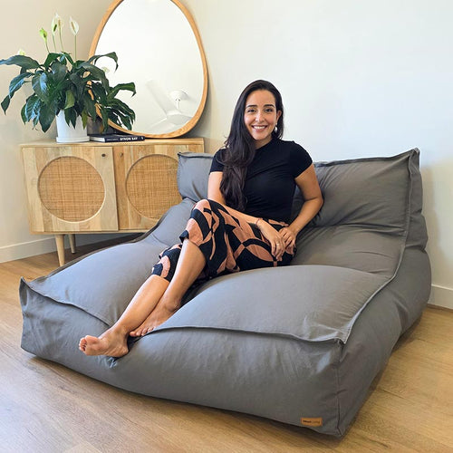 Woman seated on the Mocha Double Boss large bean bag indoor bean bag by Mooi Living in a contemporary indoor setting.