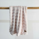 Pink throw draped over a wooden rod 