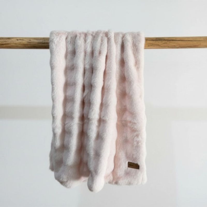 Pink throw draped over a wooden rod 