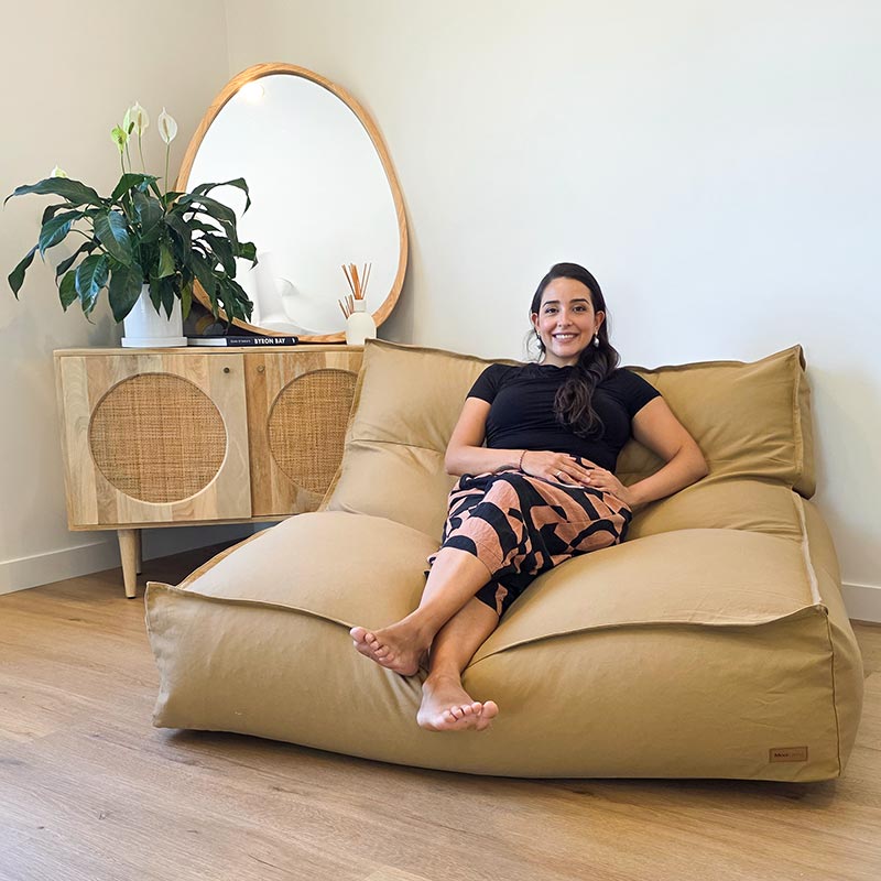 Tan Double Boss double seater bean bag chair by Mooi Living in a light-filled living room, woman seated.